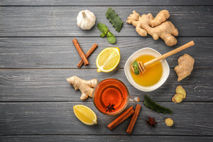 Honey in a bowl with a honey dipper. Surrounded by other herbs and fresh things 